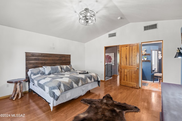 bedroom with lofted ceiling, visible vents, baseboards, and wood finished floors