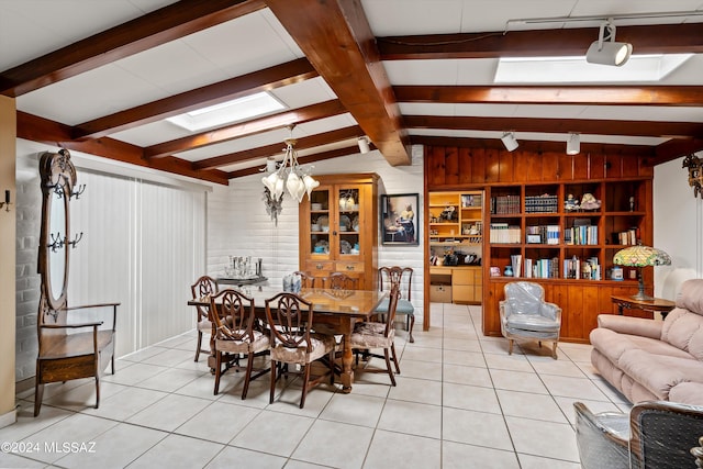 dining area featuring vaulted ceiling with beams, wood walls, an inviting chandelier, and light tile patterned floors