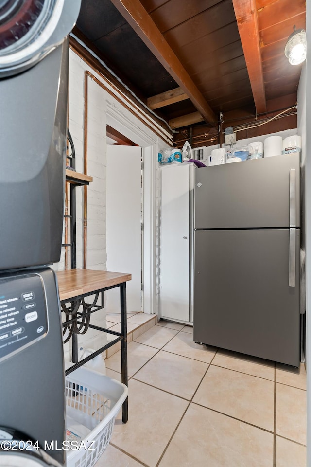 kitchen with stainless steel refrigerator, wood ceiling, light tile patterned flooring, and beam ceiling