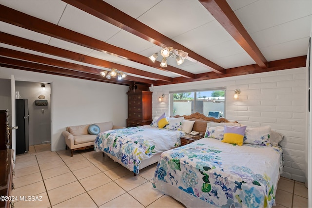 bedroom featuring black fridge, beam ceiling, light tile patterned floors, and brick wall