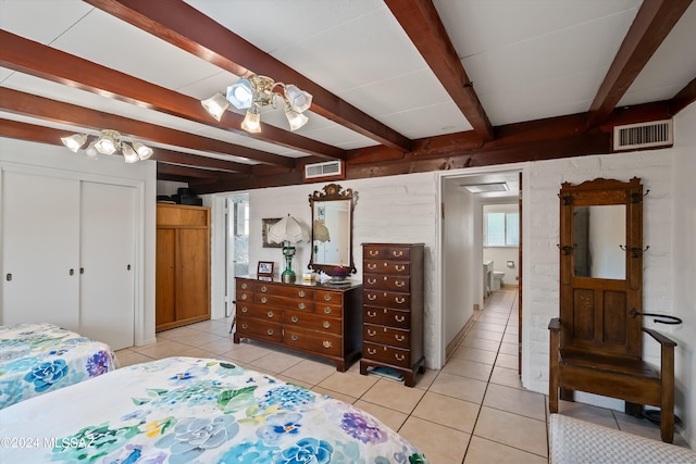 bedroom featuring beam ceiling and light tile patterned flooring