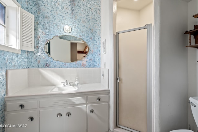 bathroom with backsplash, vanity, toilet, and an enclosed shower