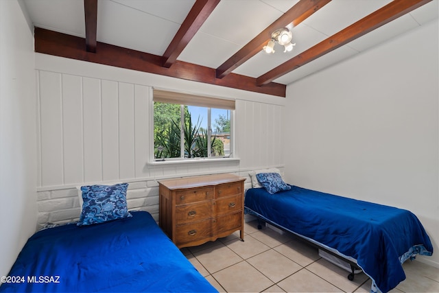 tiled bedroom featuring beam ceiling