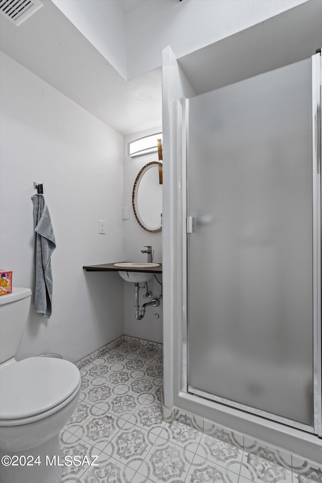 bathroom with sink, toilet, and an enclosed shower