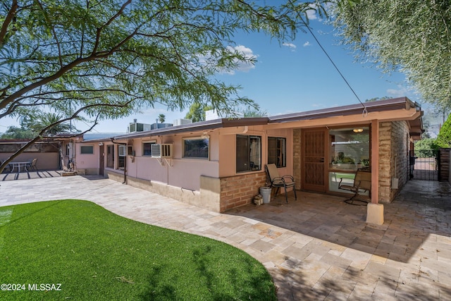 rear view of house with a lawn and a patio area