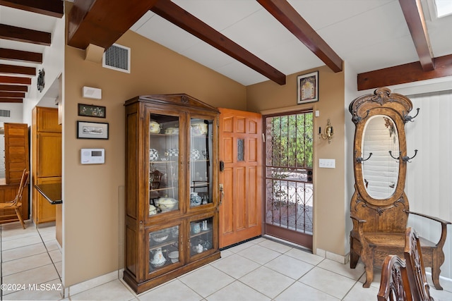 tiled foyer featuring vaulted ceiling with beams