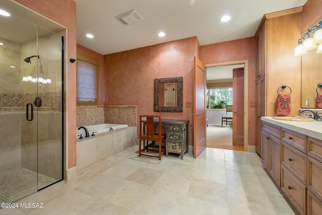 bathroom with vanity and independent shower and bath