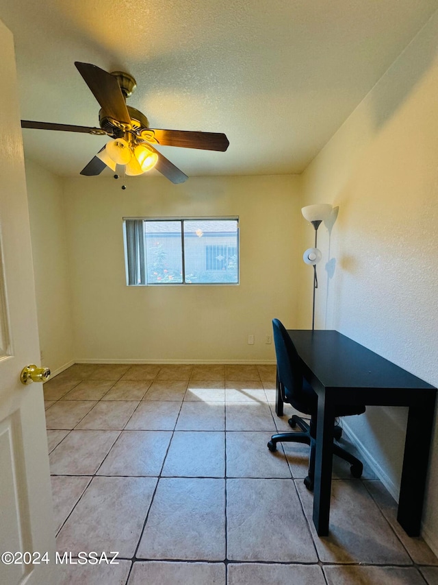 tiled office space with a textured ceiling and ceiling fan