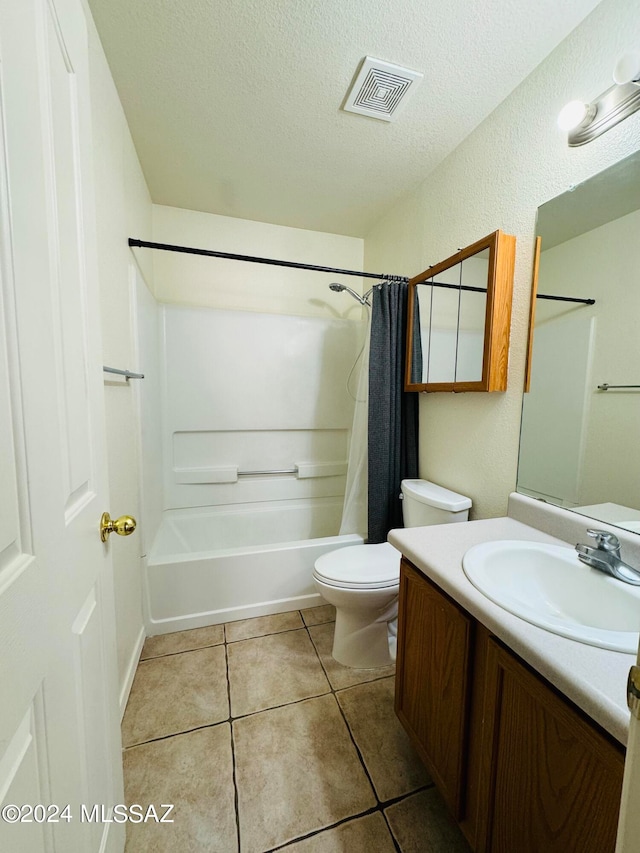 full bathroom featuring vanity, tile patterned flooring, a textured ceiling, shower / bath combination with curtain, and toilet