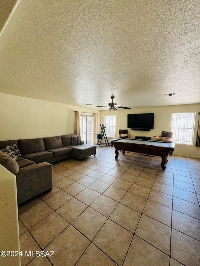 tiled living room with ceiling fan, billiards, and a textured ceiling