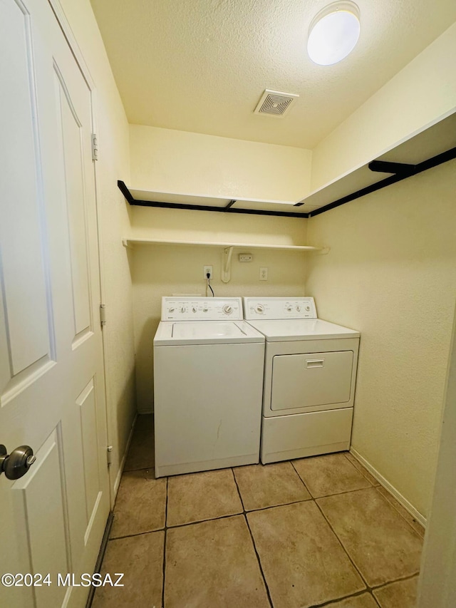 laundry room with light tile patterned flooring and washing machine and clothes dryer