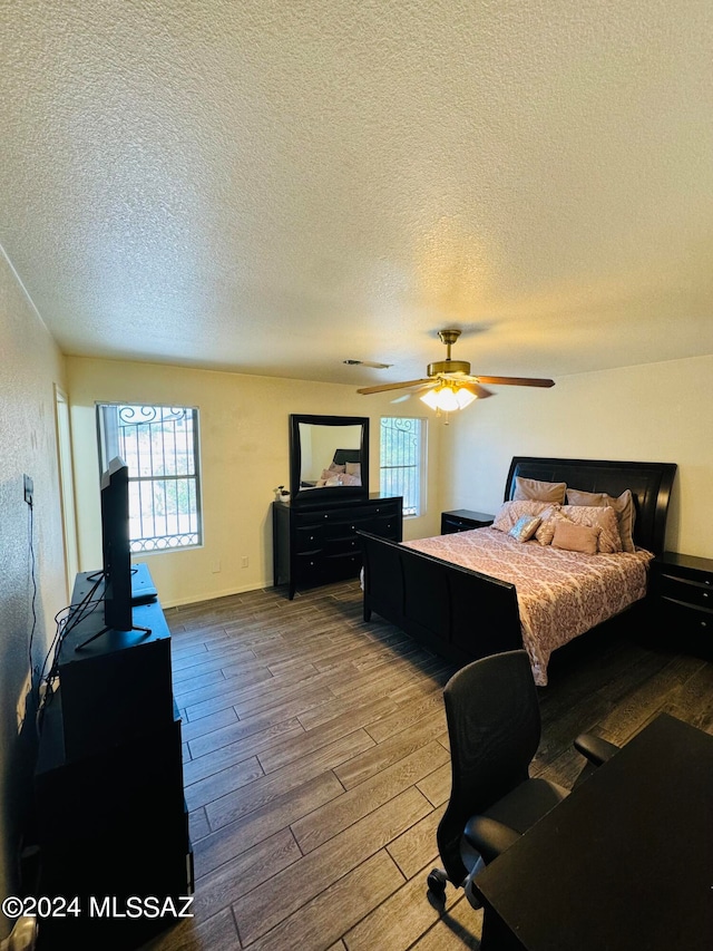 bedroom featuring ceiling fan, a textured ceiling, and wood-type flooring