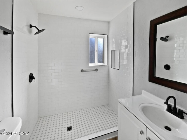 bathroom with tile patterned floors, vanity, toilet, and tiled shower