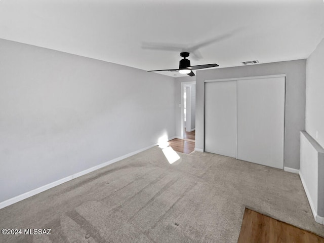 unfurnished bedroom featuring carpet, a closet, and ceiling fan