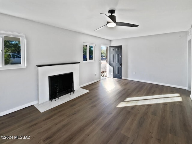 unfurnished living room with ceiling fan and dark hardwood / wood-style flooring