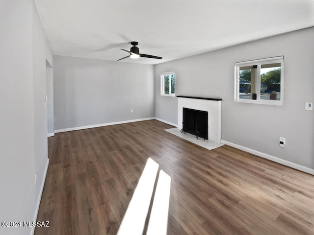 unfurnished living room featuring dark hardwood / wood-style flooring, ceiling fan, and plenty of natural light