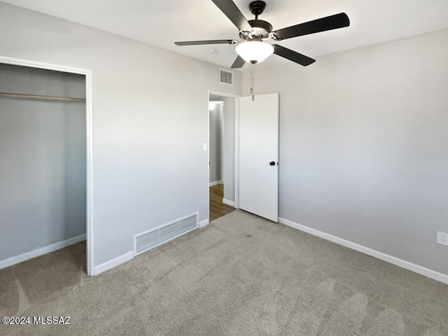 unfurnished bedroom with carpet, ceiling fan, and a closet