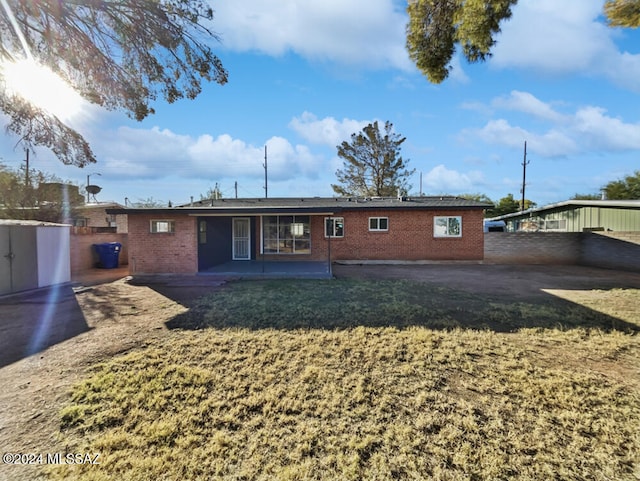 back of house featuring a patio area and a yard