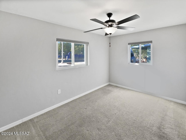 carpeted spare room with plenty of natural light and ceiling fan