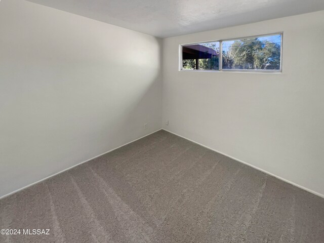 carpeted empty room with an AC wall unit