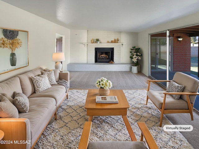 living room featuring a brick fireplace and carpet floors