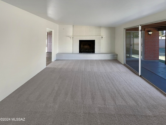 unfurnished living room with a fireplace and carpet floors