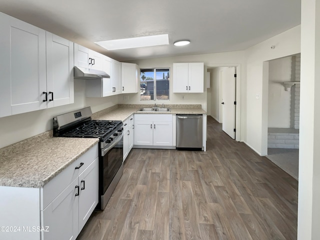 kitchen with sink, white cabinets, wood-type flooring, and stainless steel appliances