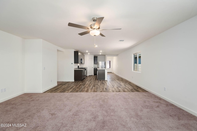 unfurnished living room featuring carpet floors and ceiling fan