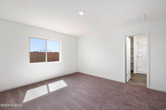 unfurnished room featuring dark carpet