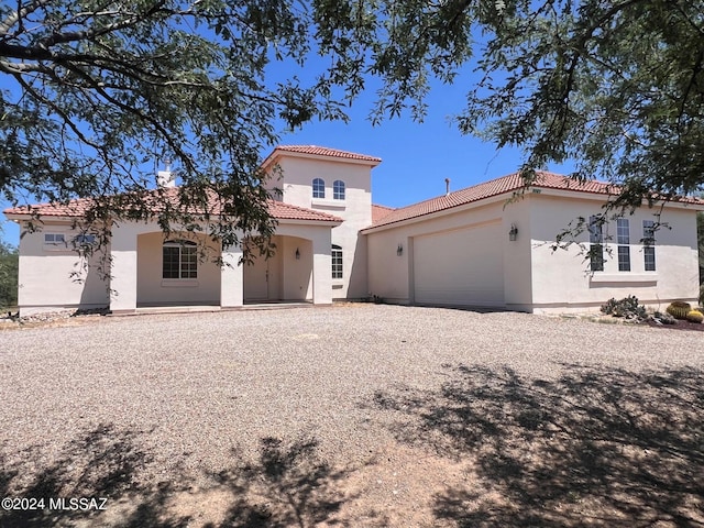 mediterranean / spanish-style house with a garage