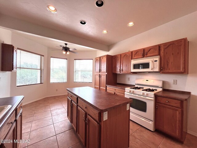 kitchen with white appliances, ceiling fan, dark countertops, recessed lighting, and a center island