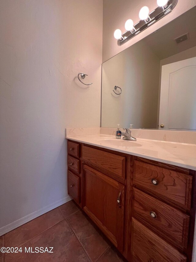 bathroom featuring baseboards, visible vents, tile patterned floors, and vanity