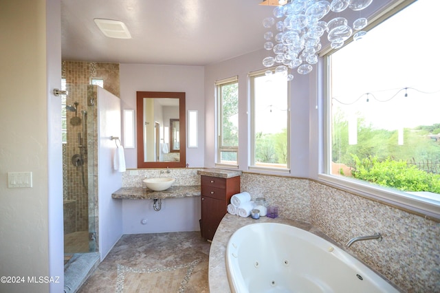 bathroom featuring independent shower and bath, sink, and a notable chandelier