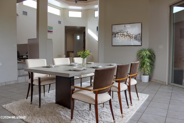 tiled dining space with a towering ceiling