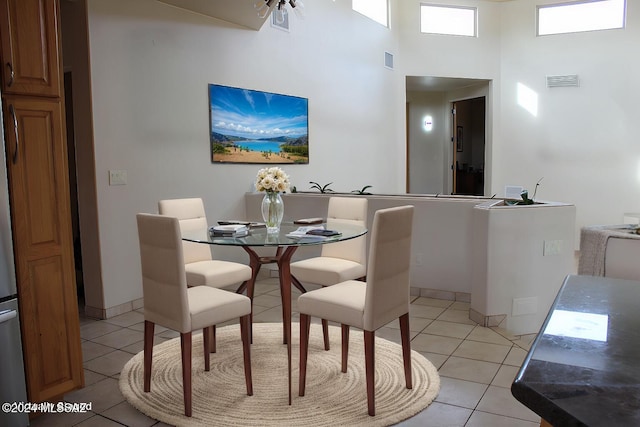 dining space featuring a high ceiling and light tile patterned flooring