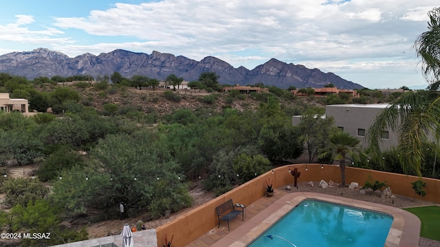 view of swimming pool with a mountain view and a patio