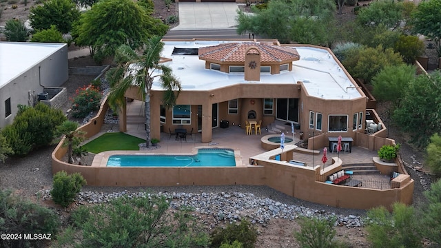 back of house with an outdoor bar, a patio area, and a pool with hot tub