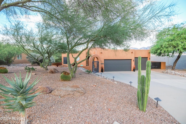 pueblo-style house featuring a garage