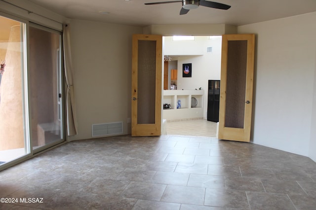 unfurnished room with ceiling fan and french doors