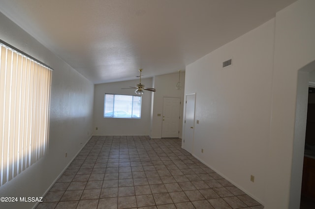 spare room featuring tile patterned floors, ceiling fan, and vaulted ceiling