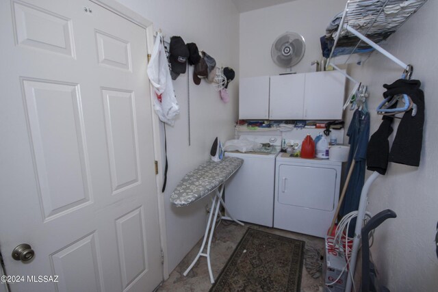 washroom with separate washer and dryer and cabinets