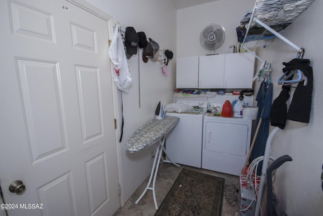 laundry room featuring cabinets and washer and clothes dryer