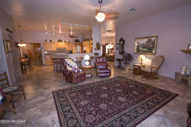 living room featuring rail lighting, ceiling fan with notable chandelier, and light tile patterned floors