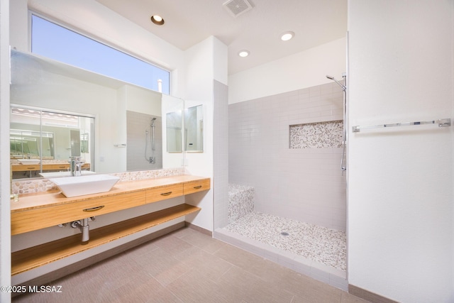 full bathroom with a walk in shower, vanity, recessed lighting, and visible vents