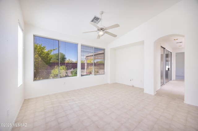 empty room with arched walkways, ceiling fan, vaulted ceiling, and visible vents