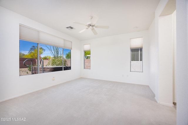 empty room featuring visible vents, carpet flooring, baseboards, and a ceiling fan