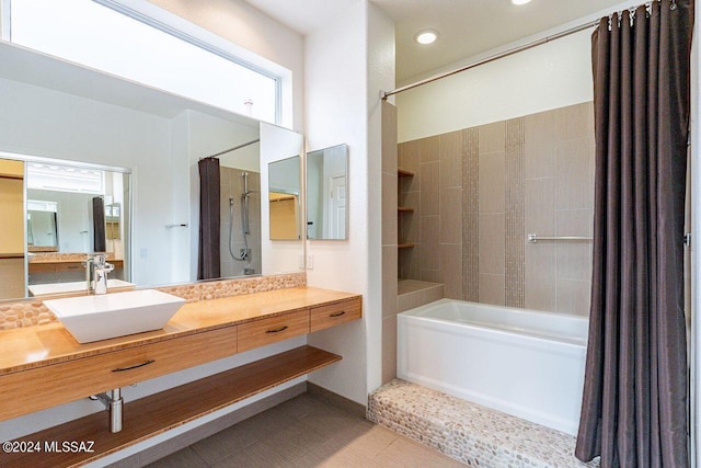 bathroom with tile patterned floors, shower / bath combo with shower curtain, and vanity