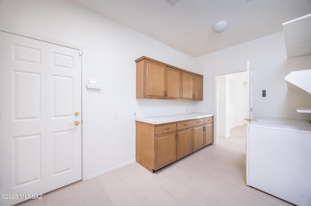 washroom with washer / dryer, light floors, and cabinet space