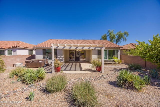 rear view of house with a patio, a pergola, a hot tub, and a tiled roof