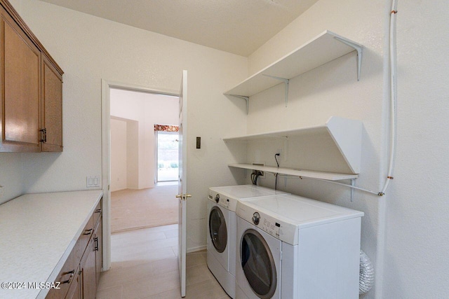 clothes washing area featuring cabinets and washer and dryer